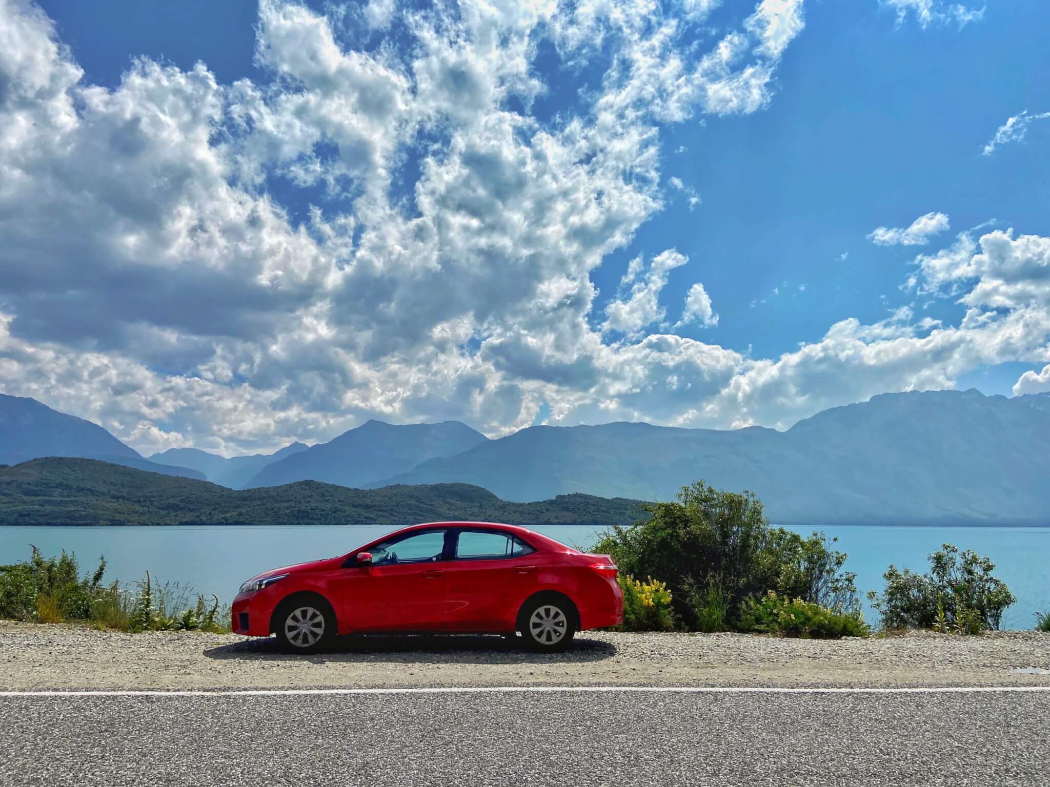 Car parked on the banks of lake wakatipu on a road trip in new zealand