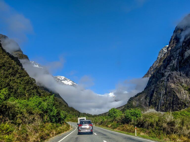 Cloud suspended over mountains on a drive to Milford Sound on New Zealand Road Trip South Island