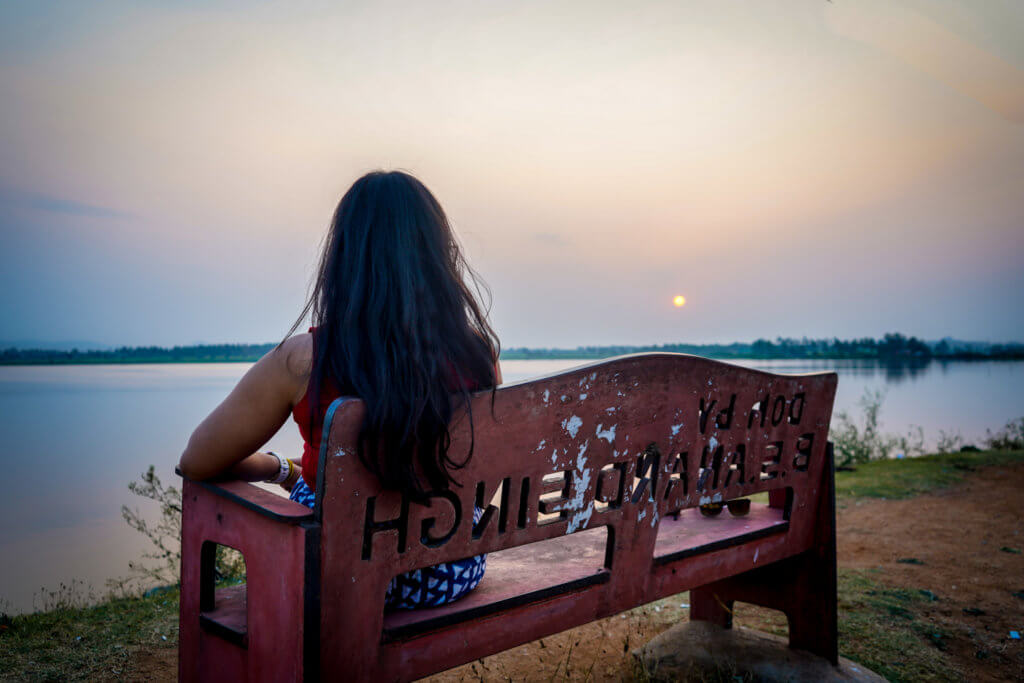 Watching the sunset while sitting on a bench beside Kamalapur Lake near Hampi