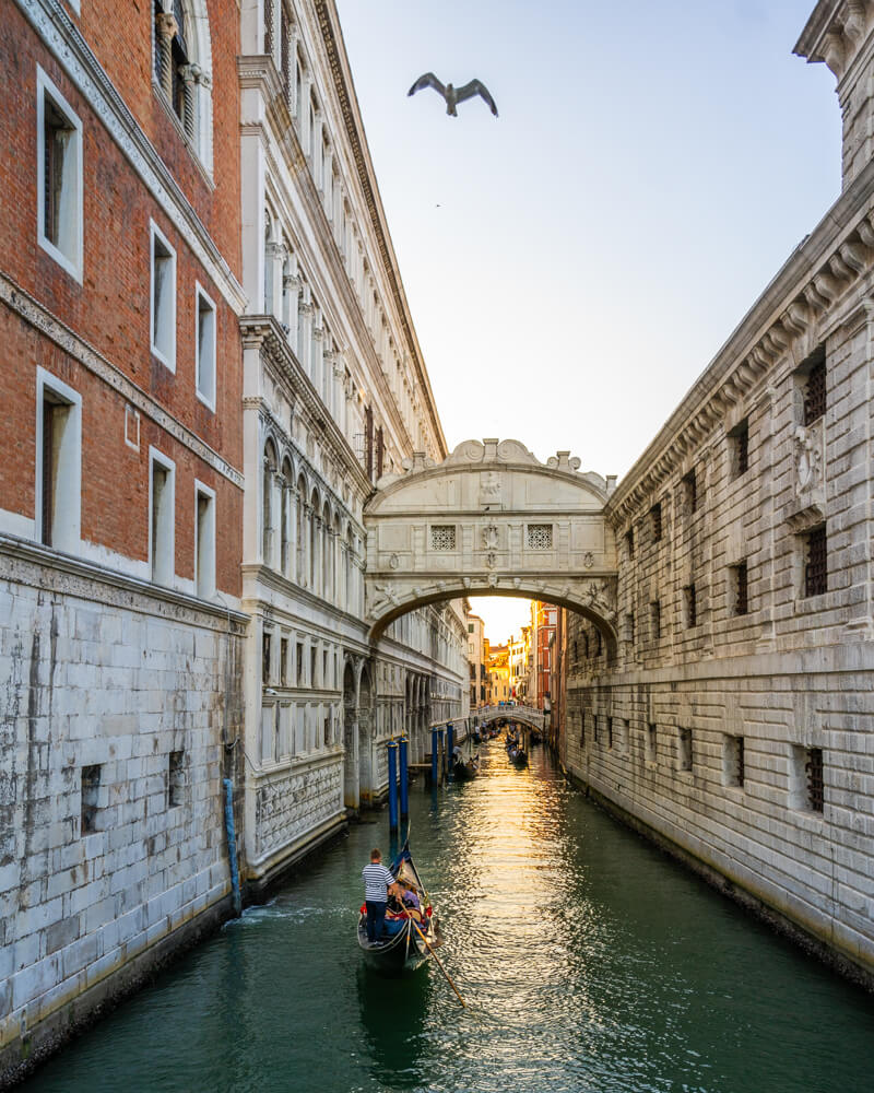 Gondolas passing under the Bridge of Sighs in the evening in Venice