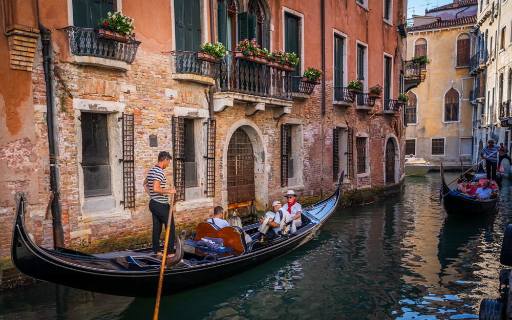 People enjoying gondola rides in Venice's narrow canals