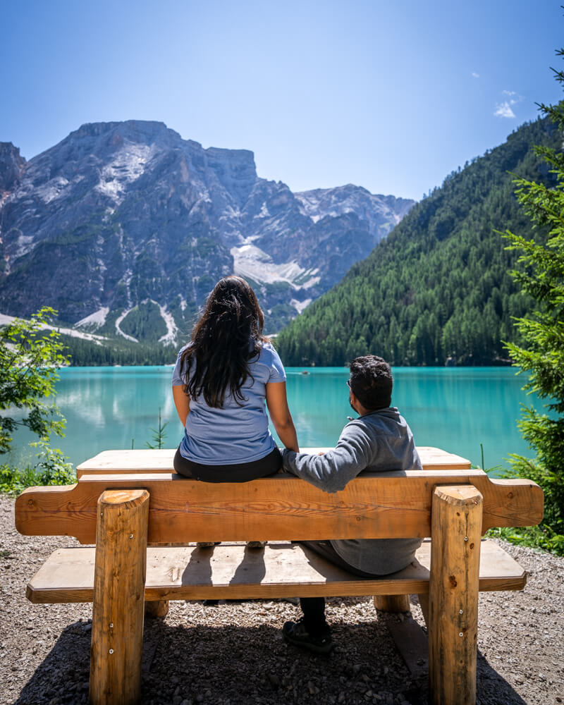 A couple sitting on a bench admiring Lago di Braies