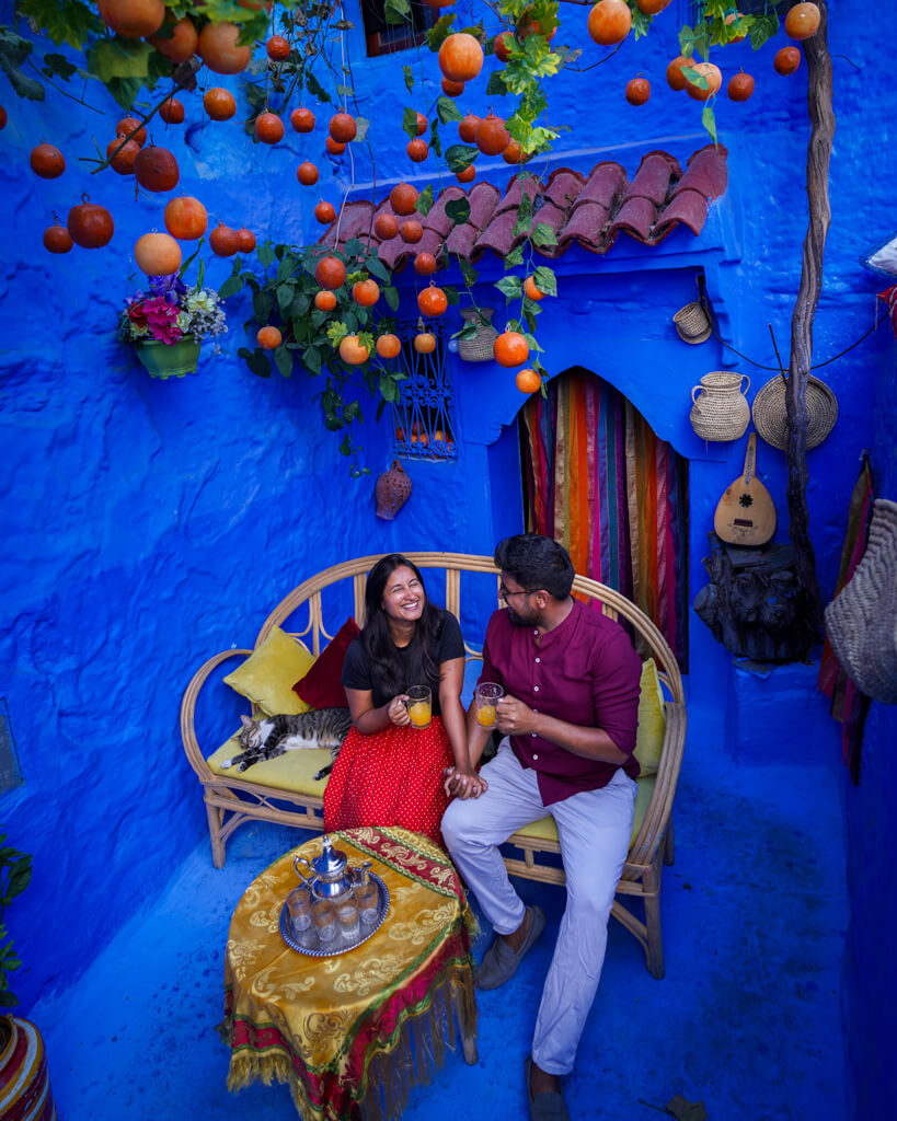 A couple merrily drinking orange juice in a picture-perfect setting in Chefchaouen in Morocco