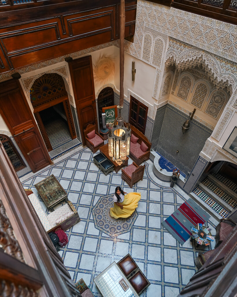 A girl twirling in the central courtyard of a Dar in Fes