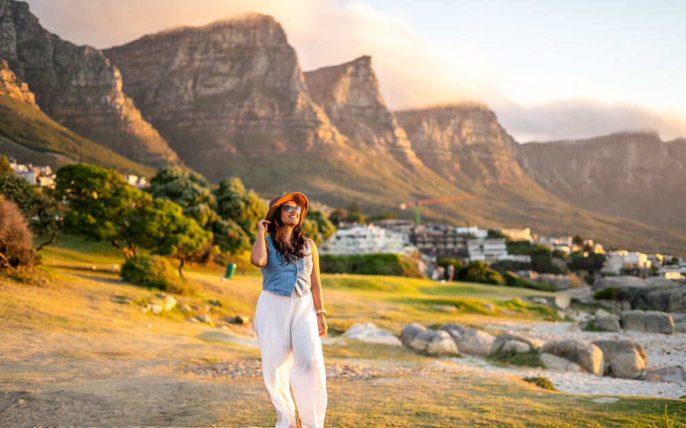 A girl with sunglasses and a hat enjoying an evening in Cape Town. 