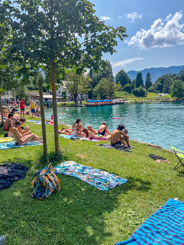 2-Day Lake Bled Itinerary: The Perfect Road Trip Guide 21 People relaxing on the grass beside Lake Bled