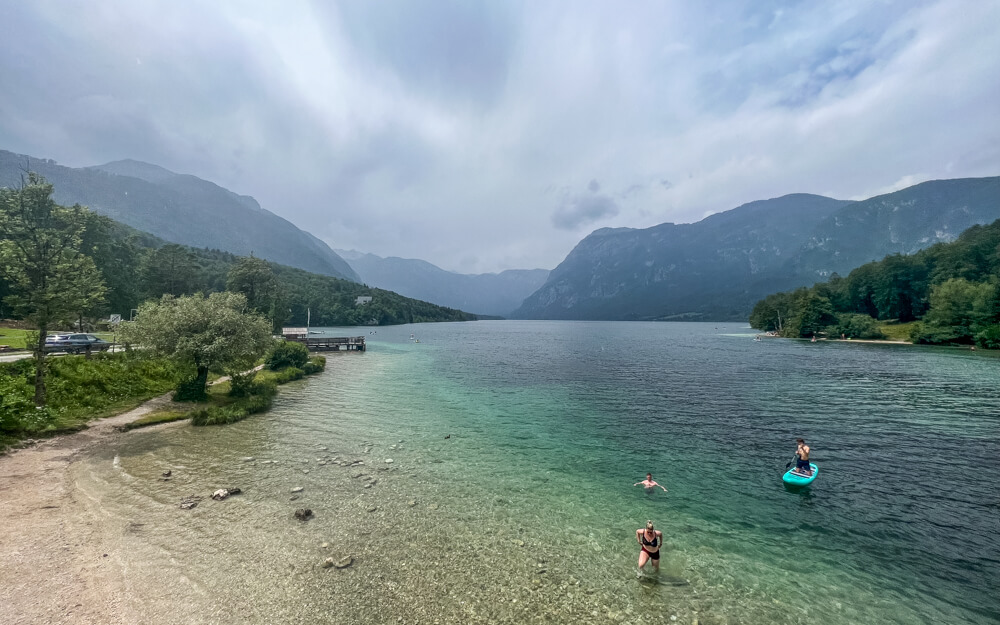 2-Day Lake Bled Itinerary: The Perfect Road Trip Guide 17 The view of serene Lake Bohinj with people swimming and SUPing in the water