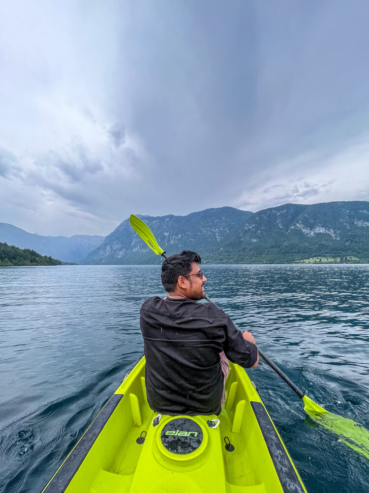 2-Day Lake Bled Itinerary: The Perfect Road Trip Guide 19 A man rowing a kayak in Lake Bohinj