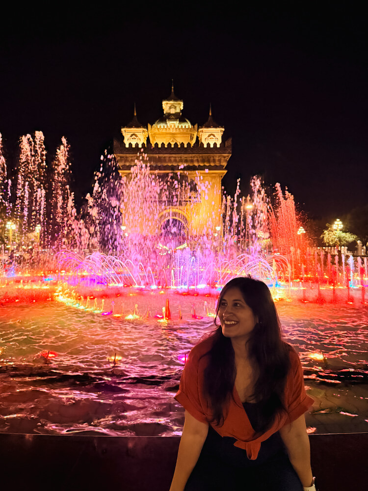 The Only Laos Itinerary You Need for 1 Week in Laos 9 A girl sitting infront of the colourful musical fountains at Patuxay Monument in Vientiane