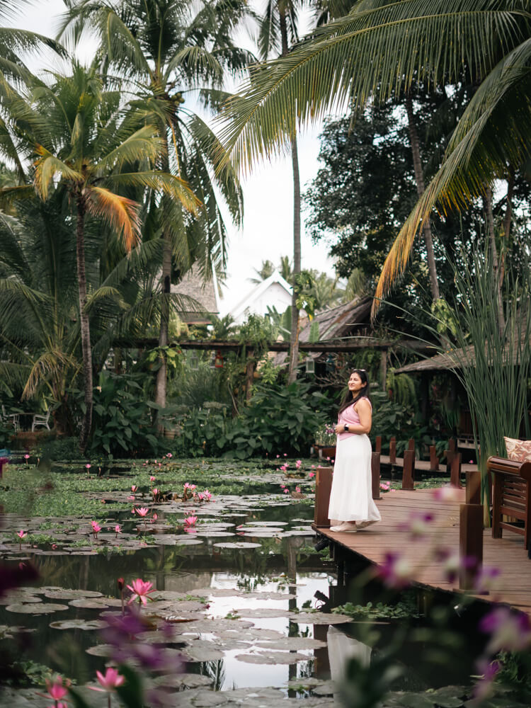 The Only Laos Itinerary You Need for 1 Week in Laos 17 A girl wearing pink and white standing by the lily pond at Manda de Laos