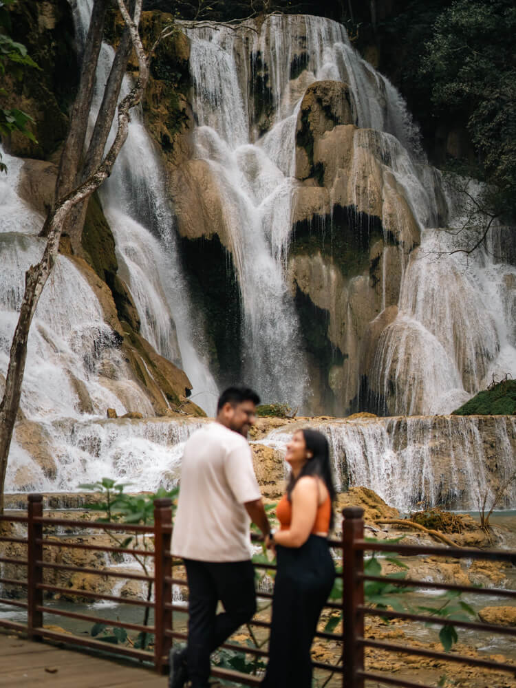 The Only Laos Itinerary You Need for 1 Week in Laos 22 A couple laughing with a background of Kuang Si Waterfall