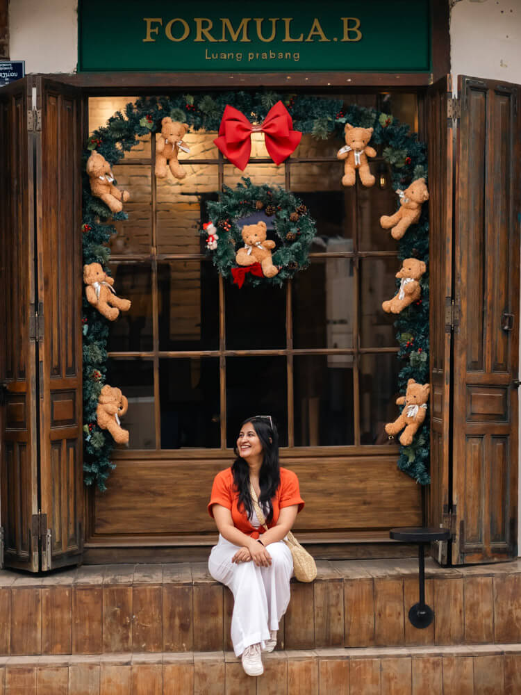 The Only Laos Itinerary You Need for 1 Week in Laos 19 A girl sitting infront of a cafe in Luang Prabang - Plan B. The cafe is decorated with teddy bears.