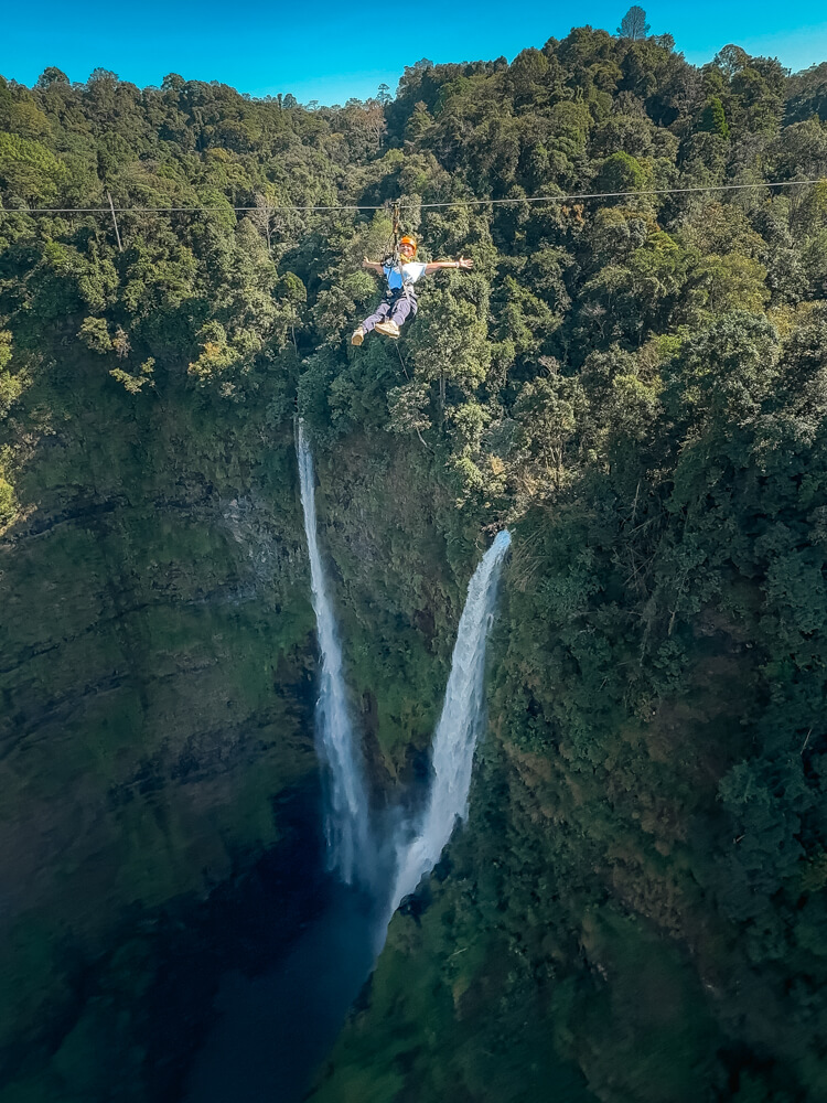 The Only Laos Itinerary You Need for 1 Week in Laos 27 A girl ziplining across a two waterfall- the highest in Laos