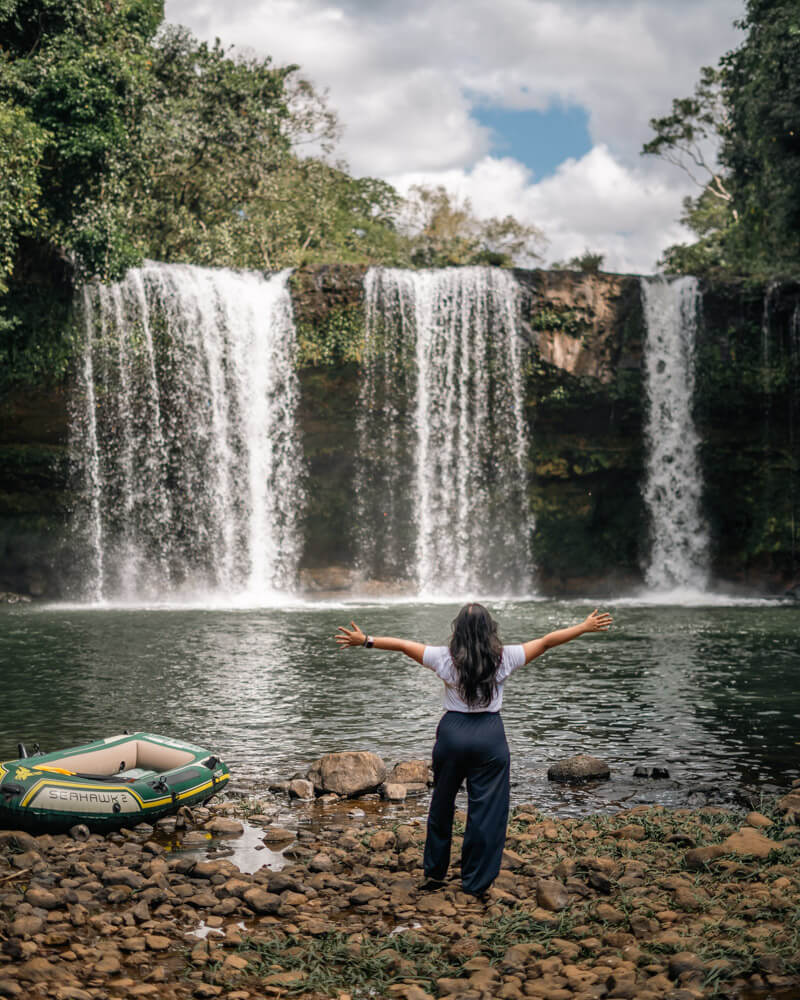 Is Pakse Worth Visiting? 7 Reasons to Go & 3 to Skip It 8 A girl with arms outstretched infront of the Tad Champee Waterfall