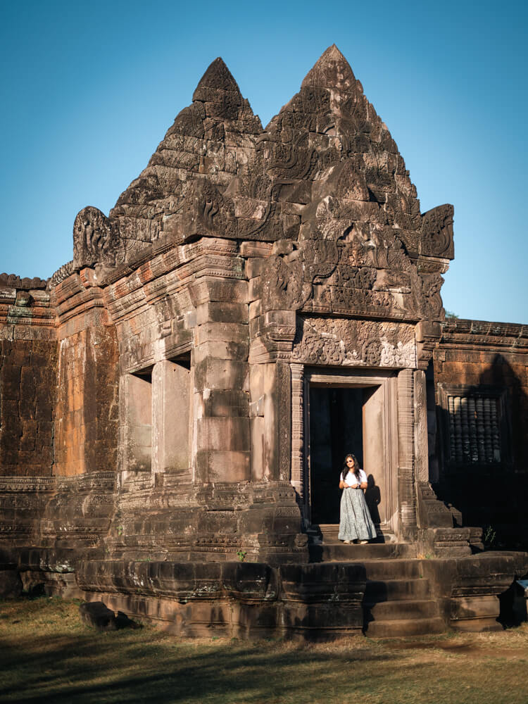 Is Pakse Worth Visiting? 7 Reasons to Go & 3 to Skip It 13 A girl standing at the doorway of the Wat Phi temple
