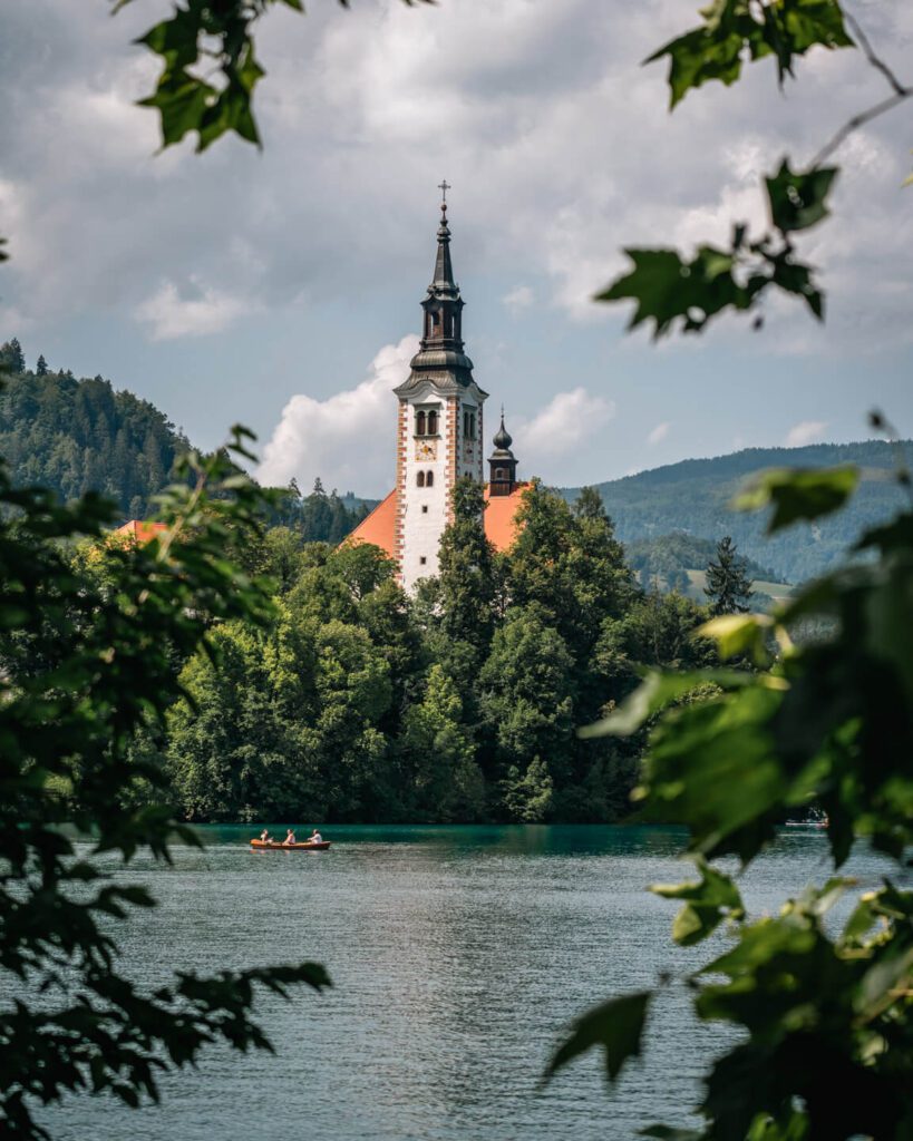 2-Day Lake Bled Itinerary: The Perfect Road Trip Guide 7 A close of the island of Lake Bled framed by leaves
