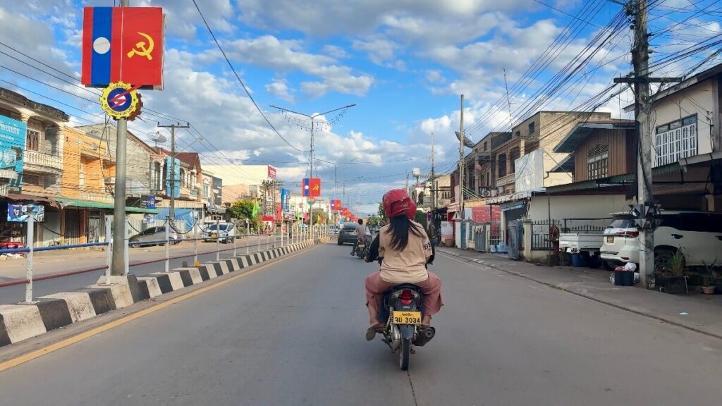 Is Pakse Worth Visiting? 7 Reasons to Go & 3 to Skip It 6 A couple on a bike riding not he streets of Pakse