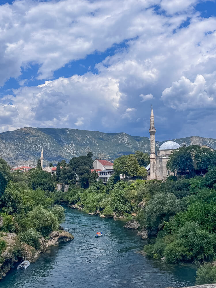 Day Trip to Mostar from Split or Dubrovnik (How to Plan It) 4 A view of the river, mosque and mountains in Mostar which is the best place to see on a day trip from Split or Dubrovnik