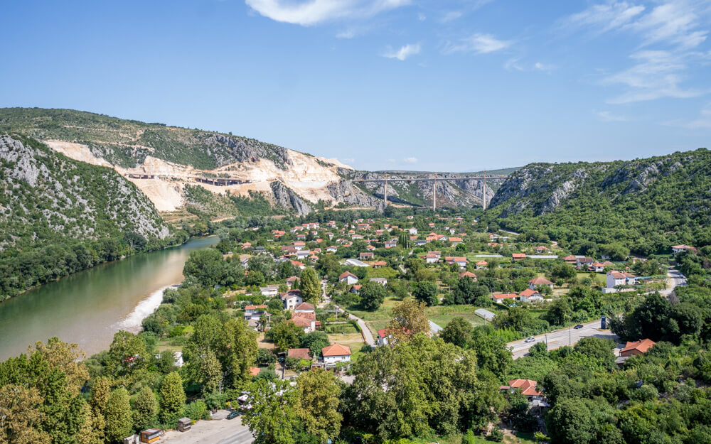 Day Trip to Mostar from Split or Dubrovnik (How to Plan It) 5 A serene view of the valley with tiny houses, mountains and bridge from the fort in Počitelj