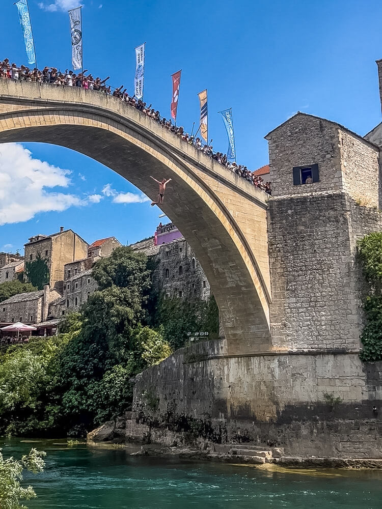 Day Trip to Mostar from Split or Dubrovnik (How to Plan It) 13 A man diving from Stari Most Bridge
