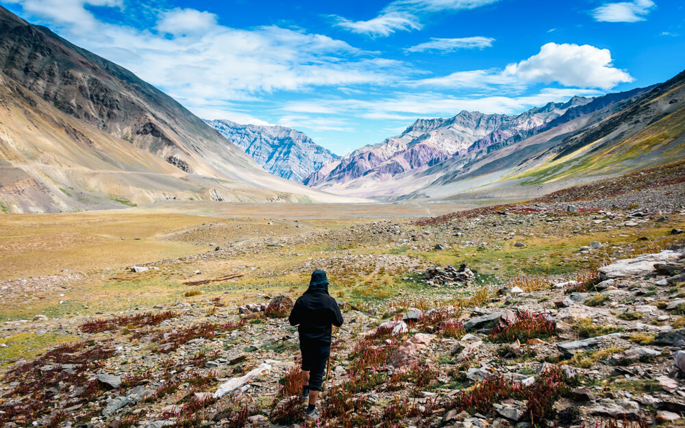 a hiker walking along the Pin Bhaba Pass Trail in the Spiti Valley of Himachal Pradesh, India.