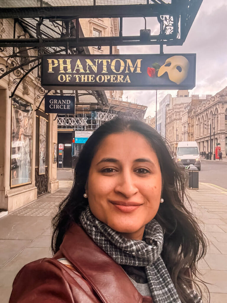 7 Best Paid Attractions in London Actually Worth Paying For 3 The author taking a selfie in front of the Phantom of the Opera signage at His Majesty's Theatre in London's West End.
